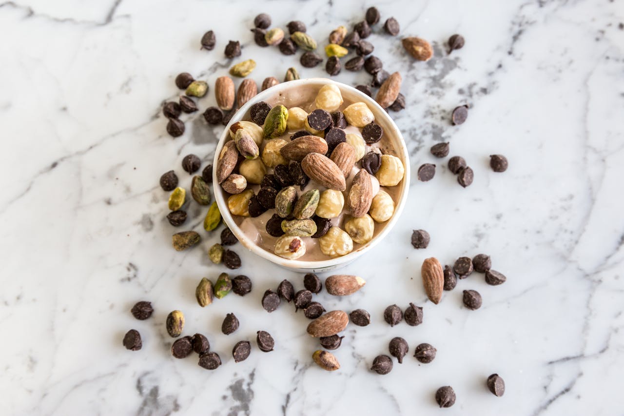 why-choose-us A bowl of mixed nuts and chocolate chips on a marble surface, perfect for healthy snacking.